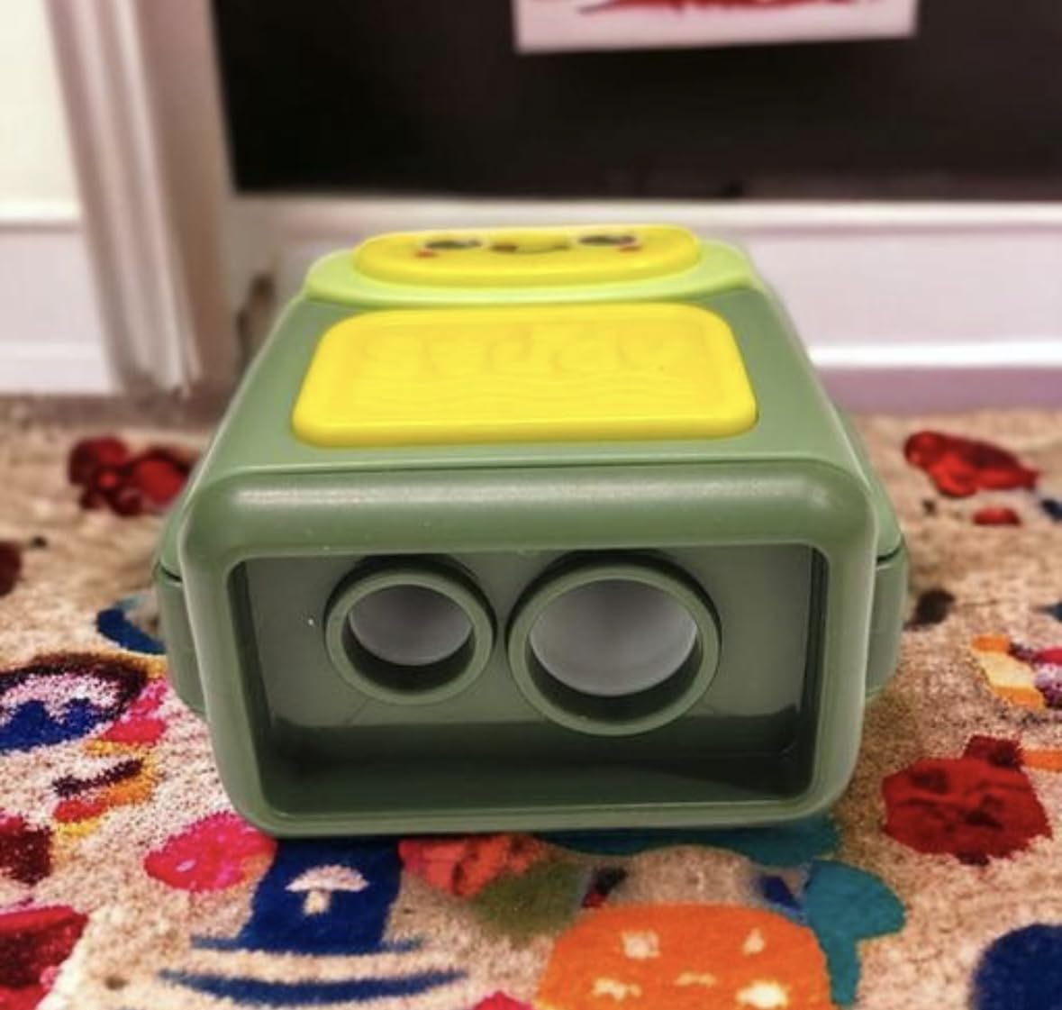 Green and yellow sharpener on a colorful rug